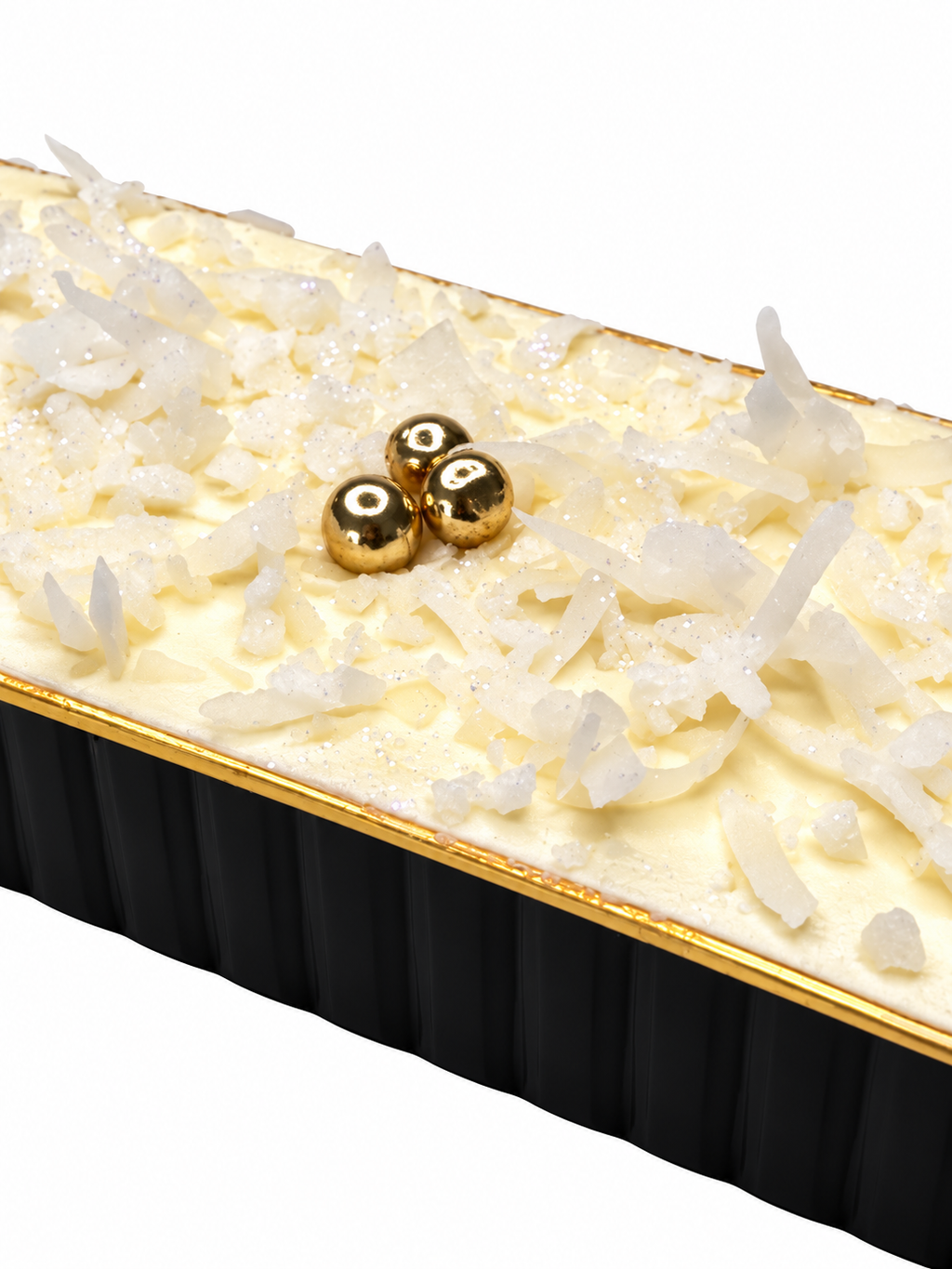 An elegant tray of Coconut sponge cake, covered in coconut buttercream, topped wth white coconut flakes, edible gold balls, white sugar crunch, and edible glitter. Perfect for corporate gifting, desk drops, product launches and hospitality gifting.